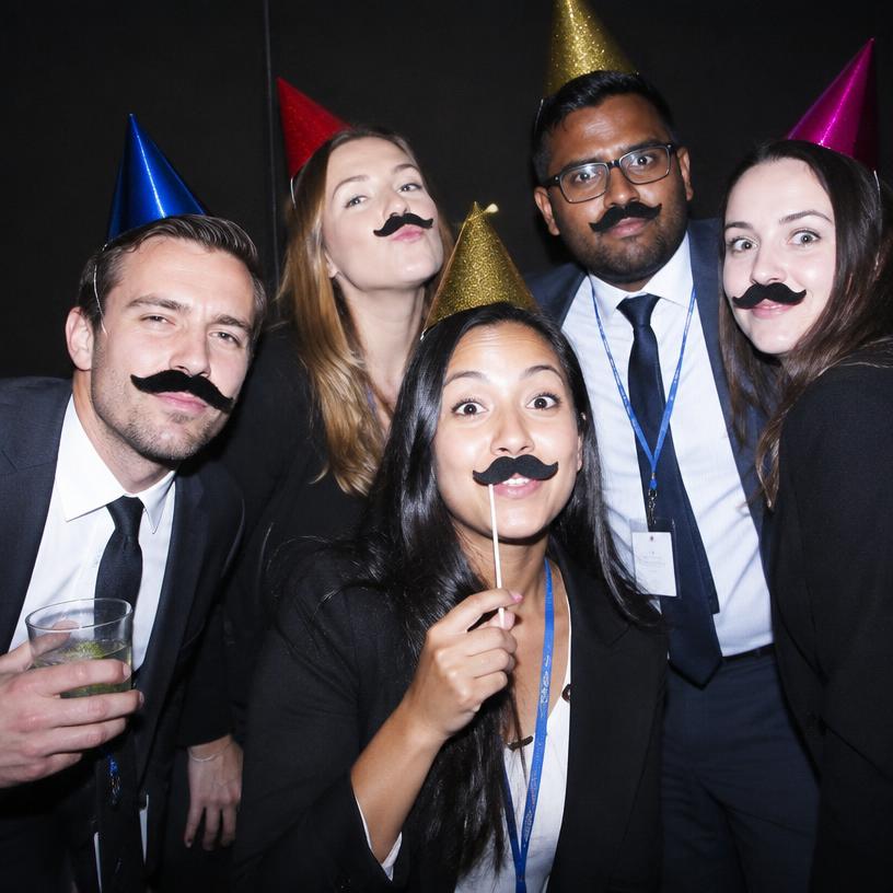 Colleagues with props in the photobooth
